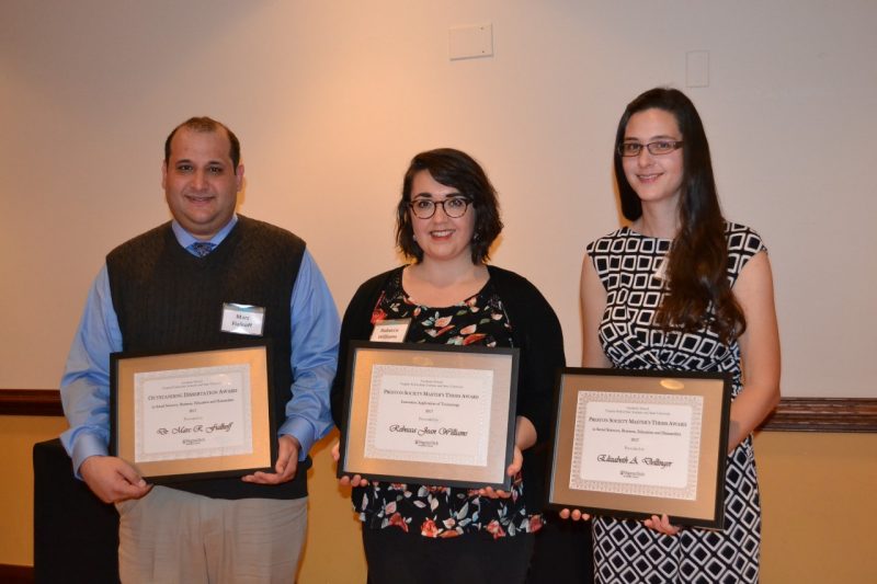 Marc Fialkoff, Rebecca Williams and Elizabeth Dellinger display the awards they received for their dissertations and master's theses during the Graduate School's awards banquet.