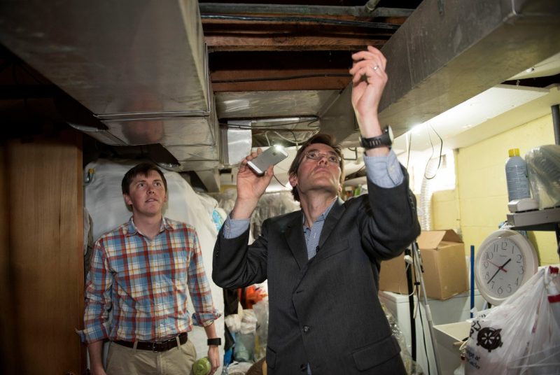 Marc Edwards and doctoral student William Rhoads (left) examine pipes in a home in Flint, Michigan, in March 2016. 