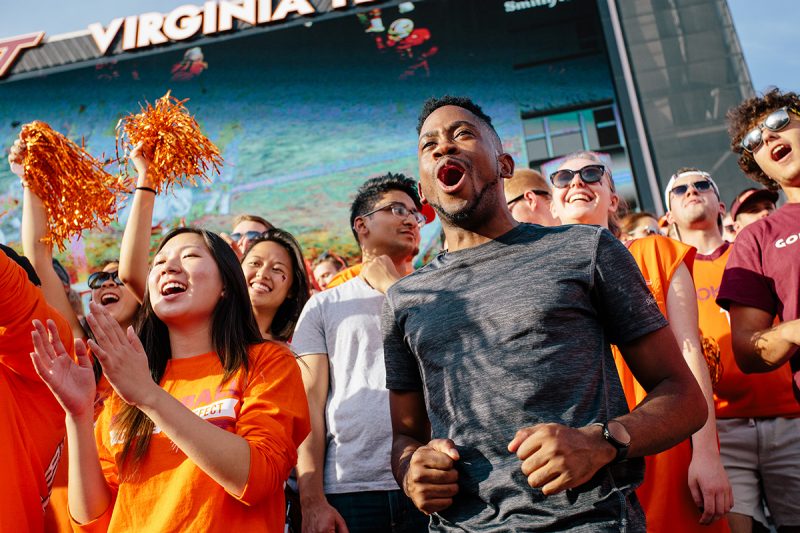 STudents cheering at a football game in Lane Stadium