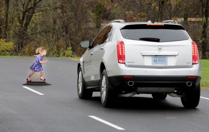 A research vehicle brakes for REMO, a remote evasive maneuvering object, during a safety demonstration on the Virginia Smart Roads.