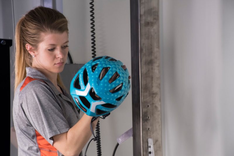 Megan Bland, a biomedical engineering and mechanics doctoral student, positions a bicycle helmet for testing. Bland conducted most of the research behind new five-star safety ratings that describe how well different helmets reduce head-injury risk. 