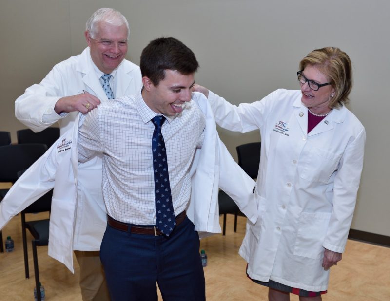 Andrew Brown helped into his white coat