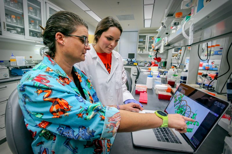 Carla Finkielstein and Abigail Workmeister review results of their experiments in the lab.
