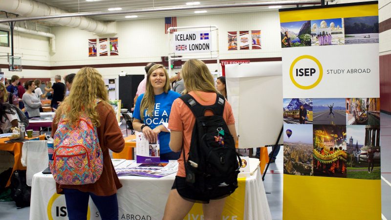 A representative from the International Student Exchange Program promotes options at the study abroad fair.