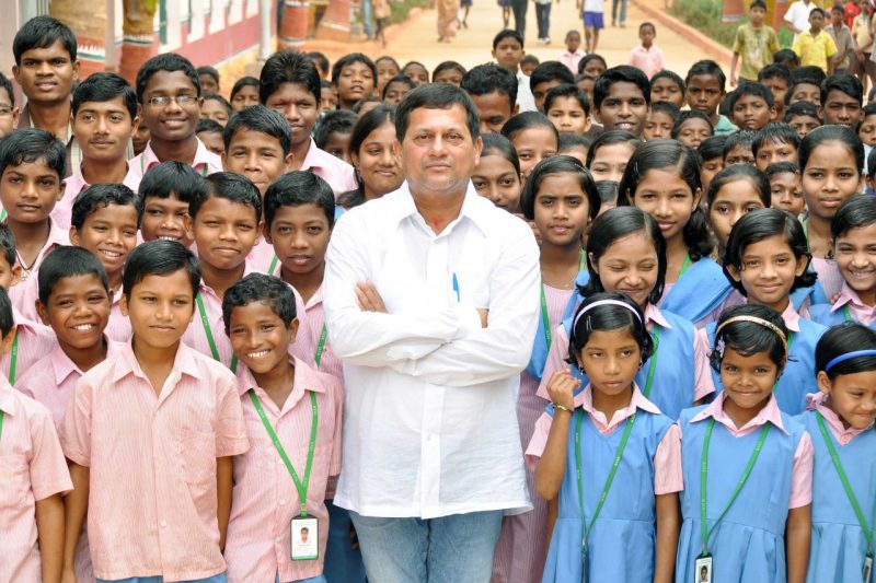 Achyuta Samanta stands in center of large crowd of KISS students in India