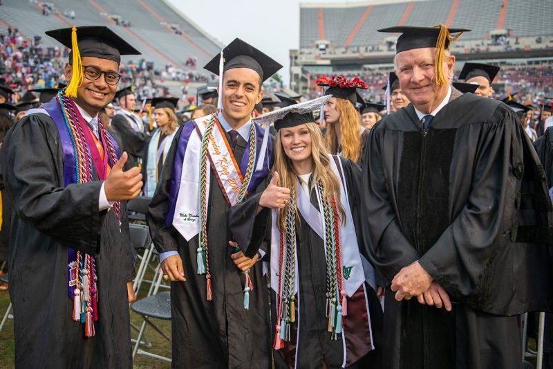 Graduates flash a thumbs up at commencement ceremonies