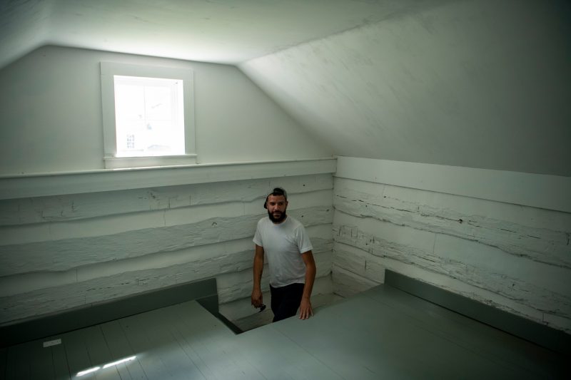 A man explores the inside of a historic home. 