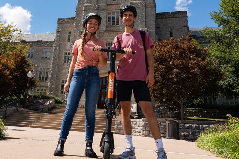 Students pose with Spin scooters