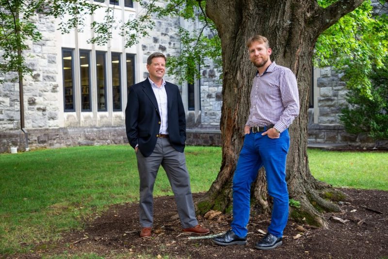 Bill Ingram and Nathan Hall stand in front of Newman Library in Blacksburg.