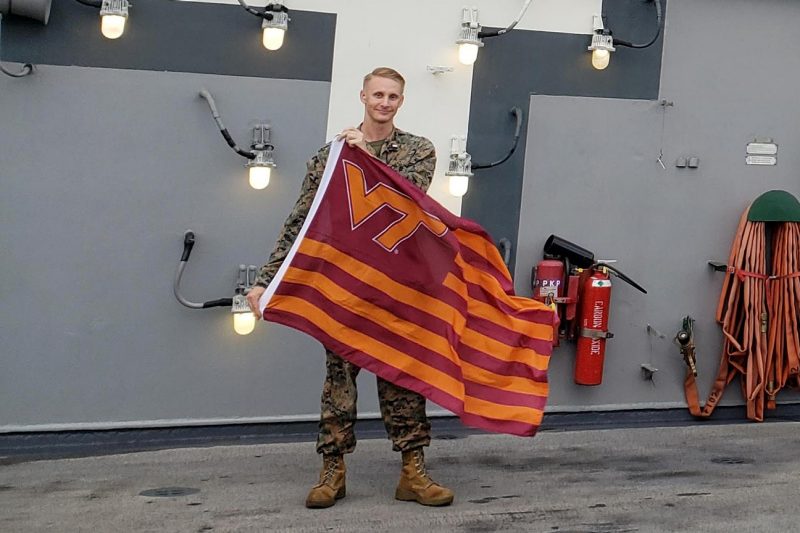 U.S. Marine Corps 1st Lt. Andrew Benton holds a Virginia Tech flag.