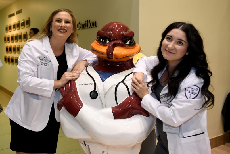students pose for a photo with the medical school HokieBird