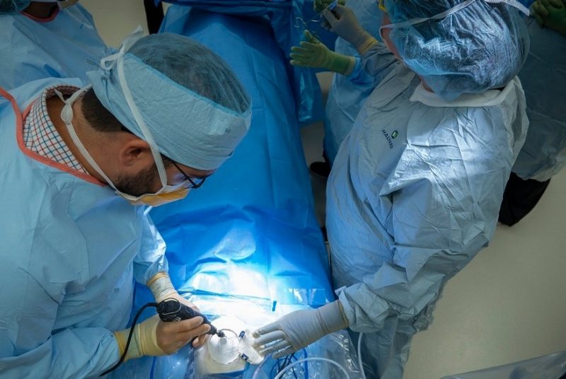 two doctors in operating room working on a patient