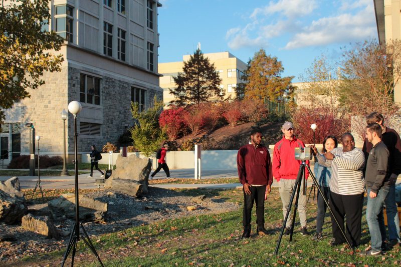 Dr. Akanmu and students work with equipment with sensors to scan and map site on campus. 