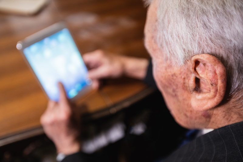 Photo of an older man looking at a mobile device
