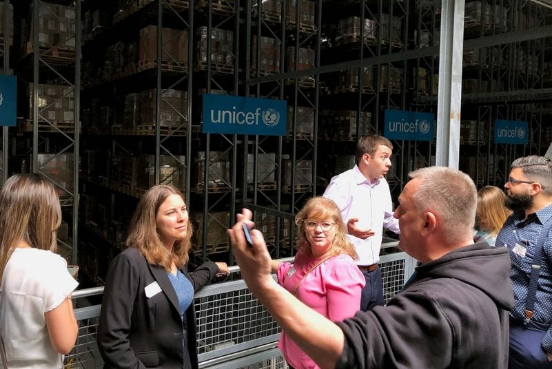 Two MBA students, Sabrina Kramer and Michele Hansen, listen as John Roger Nielsen, warehouse supervisor in UNICEF's supply division in Copenhagen, Denmark, explains how UNICEF works with government and company partners to strengthen supply chains for essential goods supporting child survival and development around the world. The students were on a study-abroad program led by associate professor Barbara Hoopes in June 2019 that visited primarily businesses in Finland, Sweden, and Denmark. 