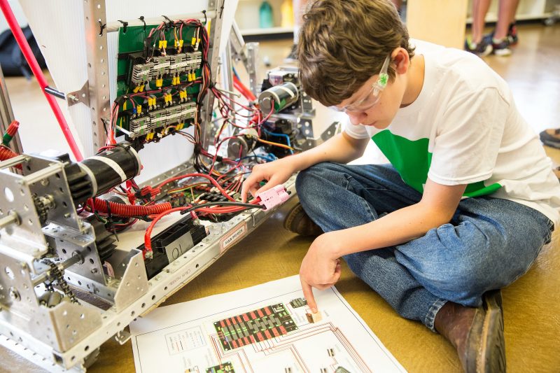 4-Her constructs a robot. 4-Her works on a robot.