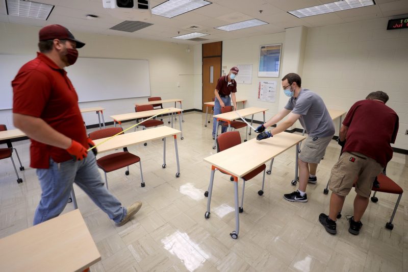 Staff adjust a classroom's layout to accommodate for fewer students