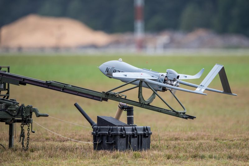 A fixed-wing drone resting on a catapult before launch. 