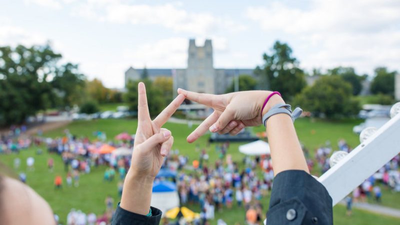 A student makes the VT symbol with hands at a past Gobblerfest event. 