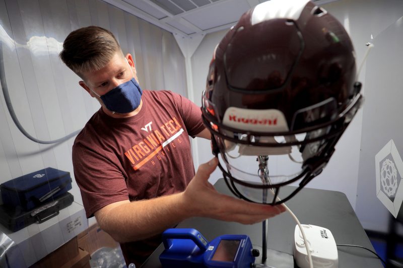 Researcher sets up spray test for football face shield. 