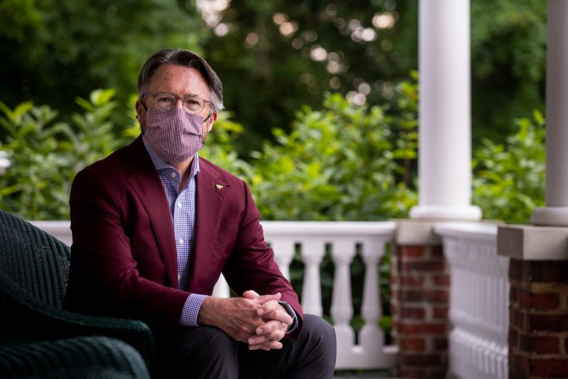 President Tim Sands poses in a maroon blazer for a photo outdoors donning a mask