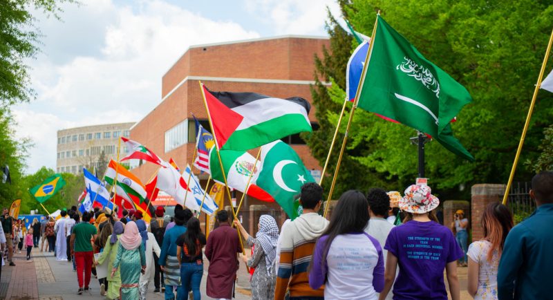 International students walking with flags.