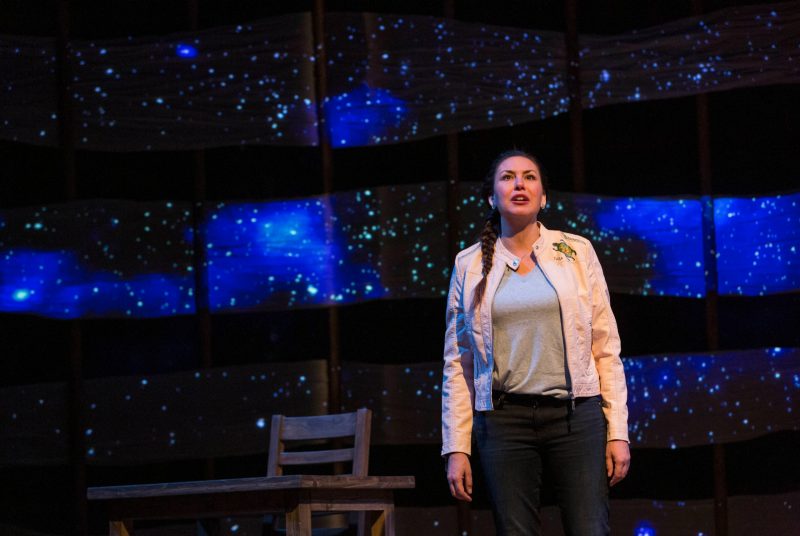 DeLanna Studi performs on a starry, blue-lit stage.