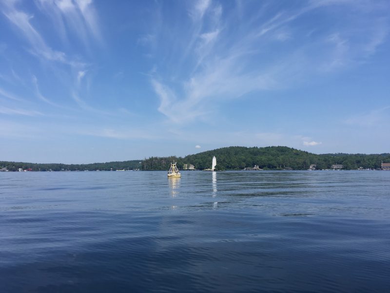 Lake Sunapee in New Hampshire on a bright, nearly cloudless day. In the distance is a buoy that has monitored the quality of the water since 2007.