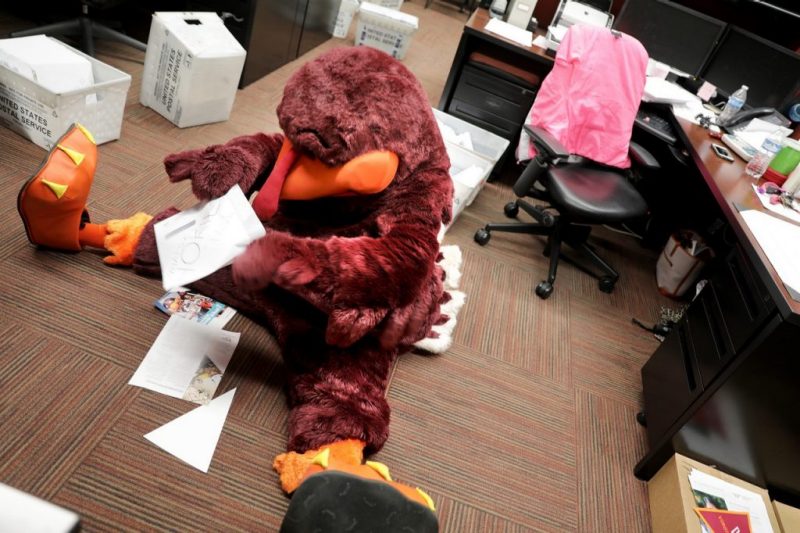 Hokie Bird in an office surrounded by papers