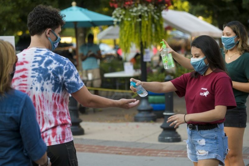 People giving out hand sanitizer. 
