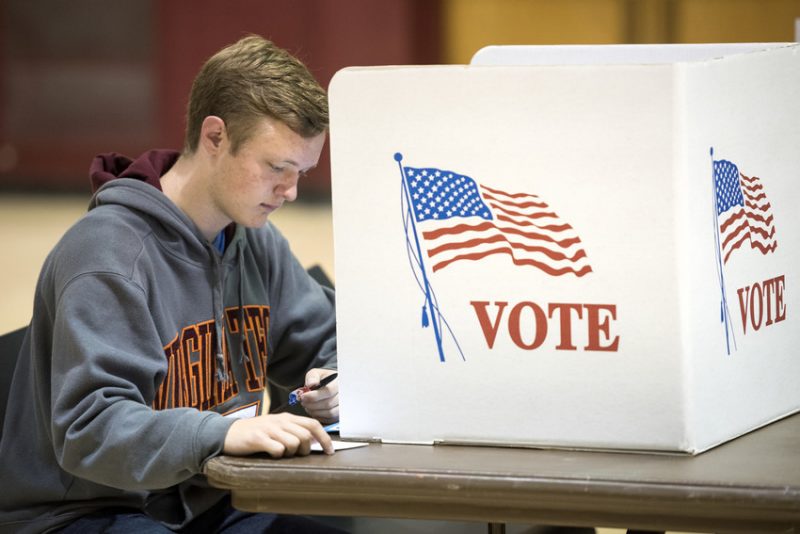 image of young man voting at Virginia Tech 