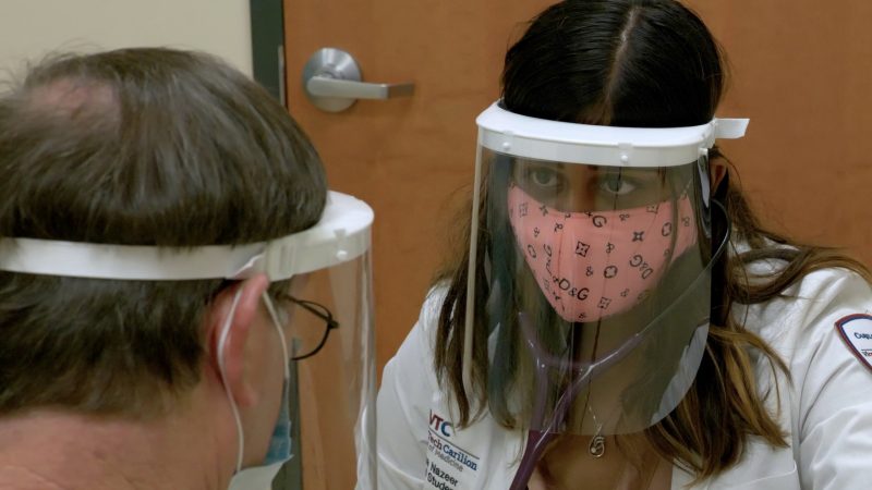 Student interacts with standardized patient wearing PPE