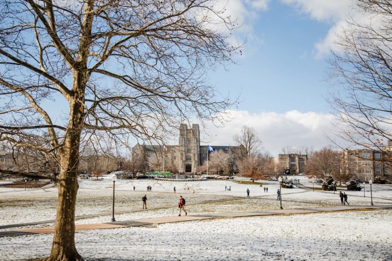 people walking across a lightly snow covered field on Virginia Tech campus