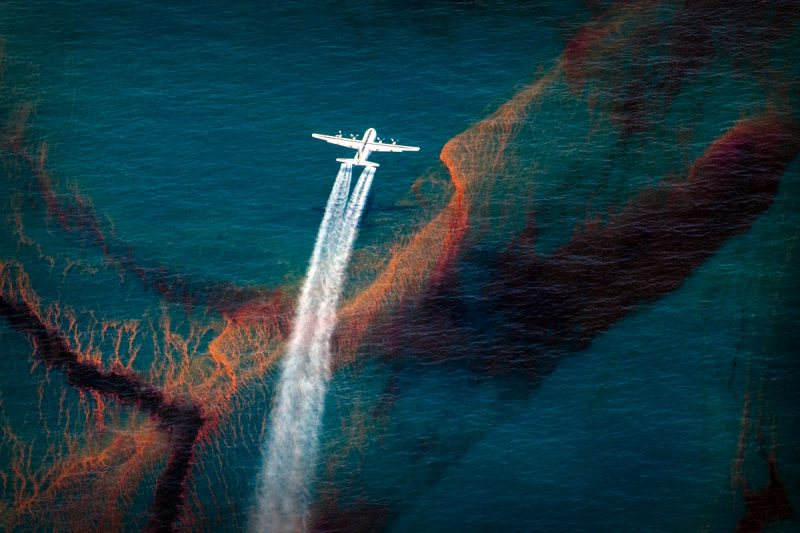 A white C-130 plane sprays dispersant on the deep blue waters of the Gulf of Mexico, after the Deepwater Horizon oil spill.