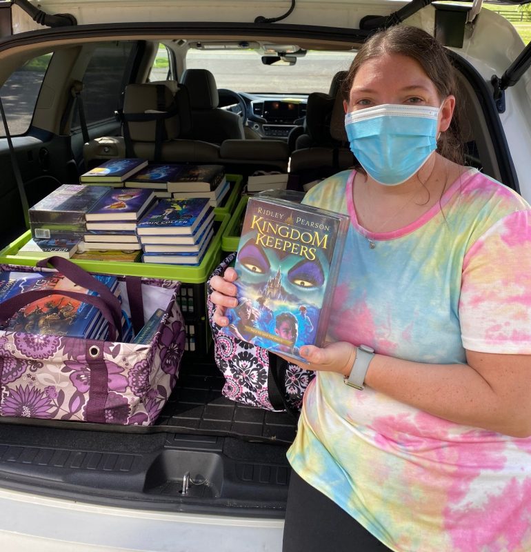 4-H Agent Alyssa Walden picks up a car load of books provided by the Molina Foundation.