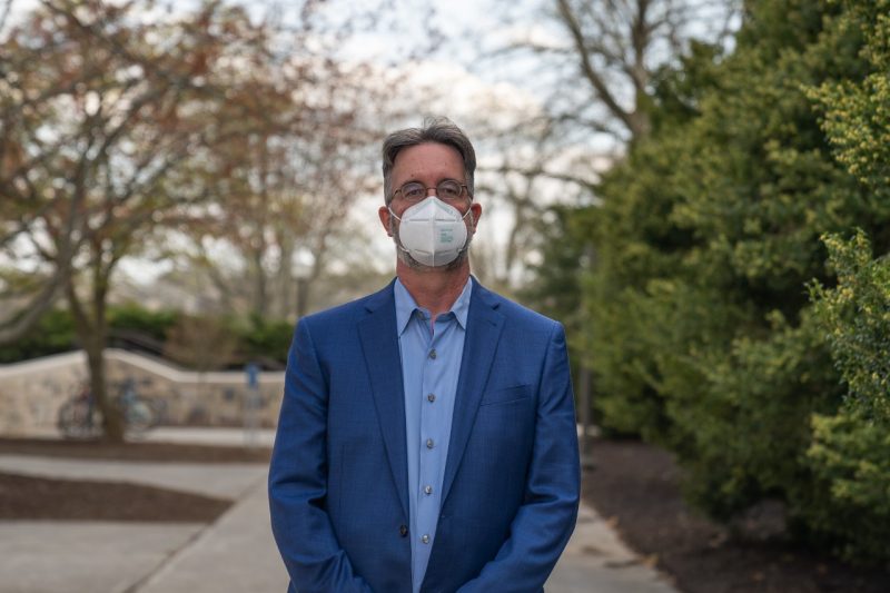Chris Zobel, with mask on, poses for his portrait outside Pamplin Hall. Photo by Justin Rocha/PRISM.