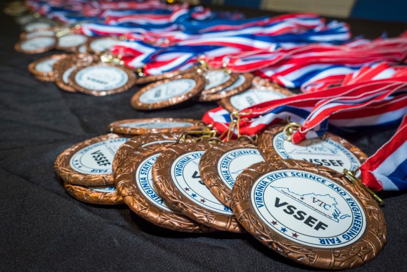 Red, white, and blue award medals draped across a table