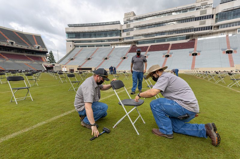 Crews check seat alignment and spaces in Lane Stadium