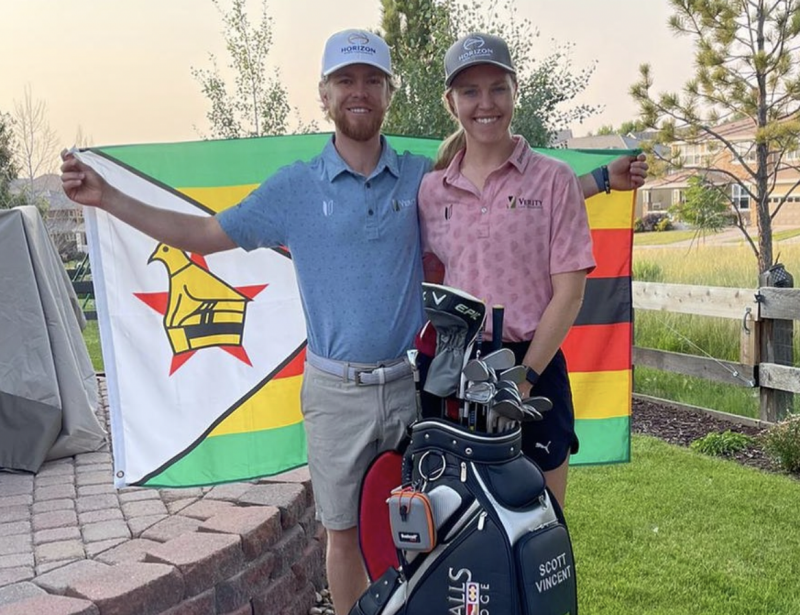 Scott Vincent with wife Kelsey and a Zimbabwe flag in the background