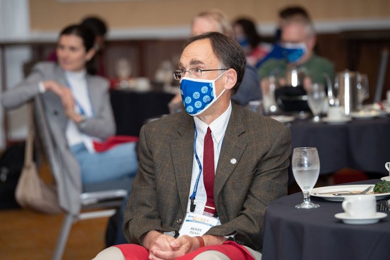 Winners of the coveted Kepler Award are kept tightly under wraps, and are cleverly announced by revealing clues to the recipient’s identity at the ION GNSS+ annual conference. Psiaki, seen here at the moment of realization that he is the 2021 honoree, listens to clues related to his professional career and personal life. Photo courtesy of the Institute of Navigation.