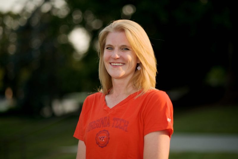 Image of Robin Queen, in an orange Virginia Tech t-shirt, on campus. 