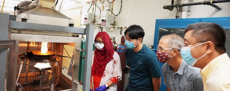 Graduate students Rezawana Islam and Seokgyun Ham observe a flame with Brian Lattimer and Rui Qiao in the EXTREME lab.