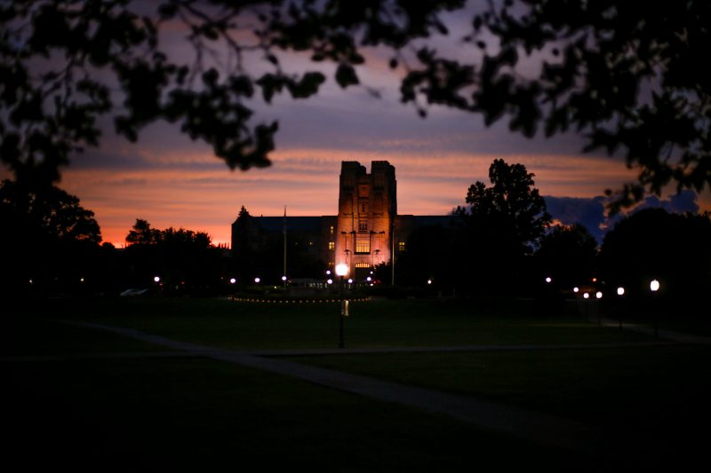 Gray Burruss Hall lit up in orange during a colorful sunset.