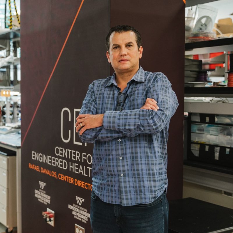 Rafael Davalos stands in front of a sign in his lab which reads, "Center for Engineered Health"
