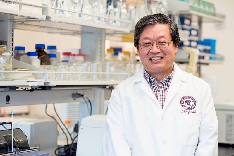 X.J. Meng, University Distinguished Professor at the Virginia-Maryland College of Veterinary Medicine, stands in his lab with a bright white coat on. This photo was taken prior to COVID-19 protocols.
