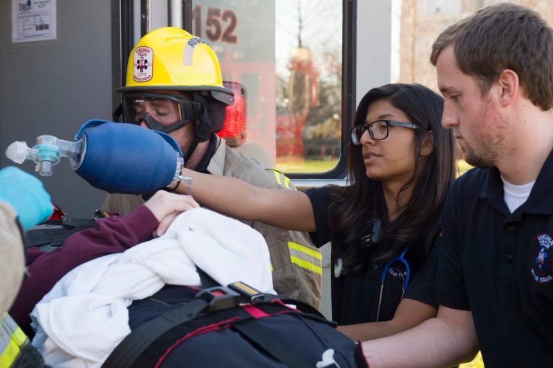 Rescue squad members tend to patient being transported into ambulance during drill