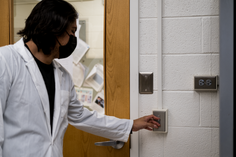Student turning off the light in the Allen Lab