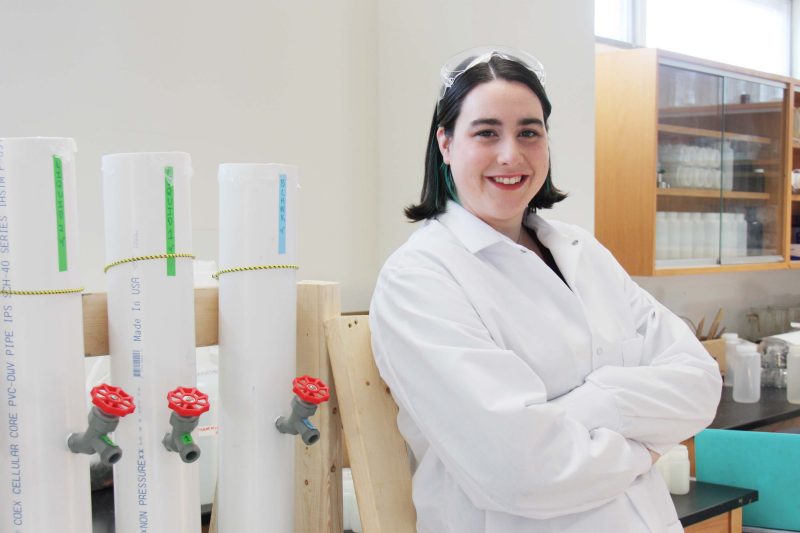 A female graduate student standing next to a lab bench.
