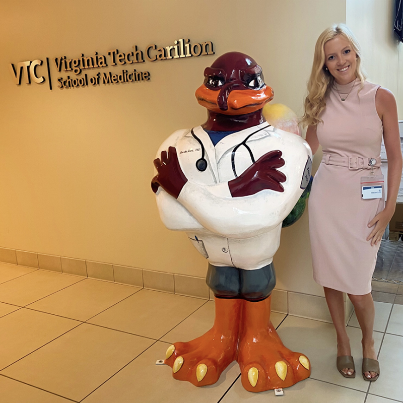 Ali Toloczko smiles beside a statue of the Hokie Bird at the Virginia Tech Carilion School of Medicine in Roanoke.