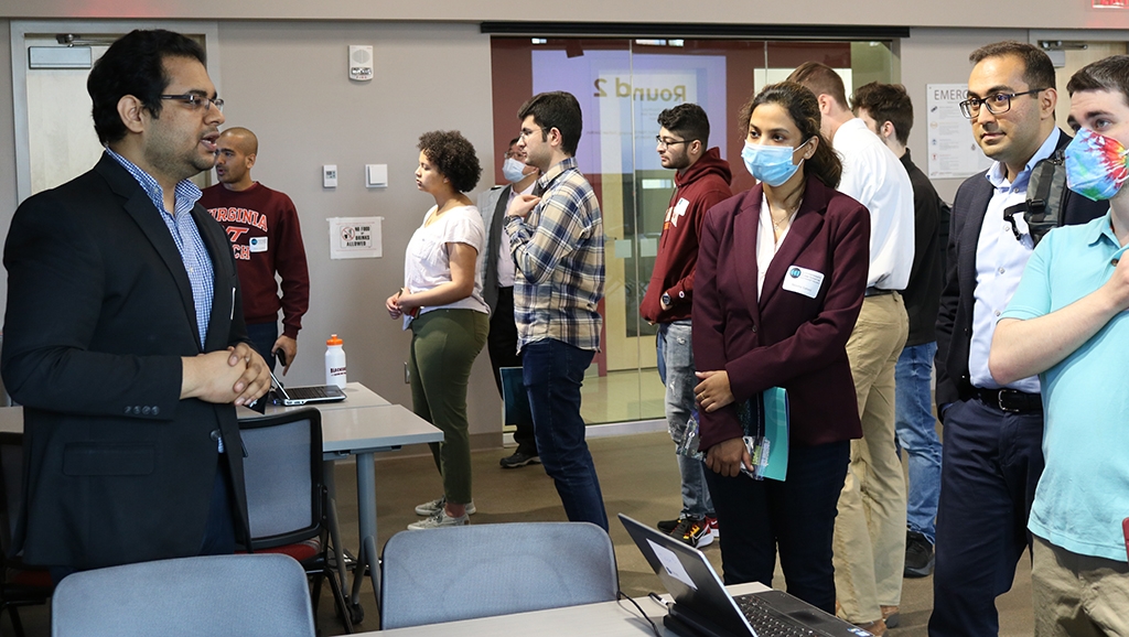 Student researchers gather around an electronic screen